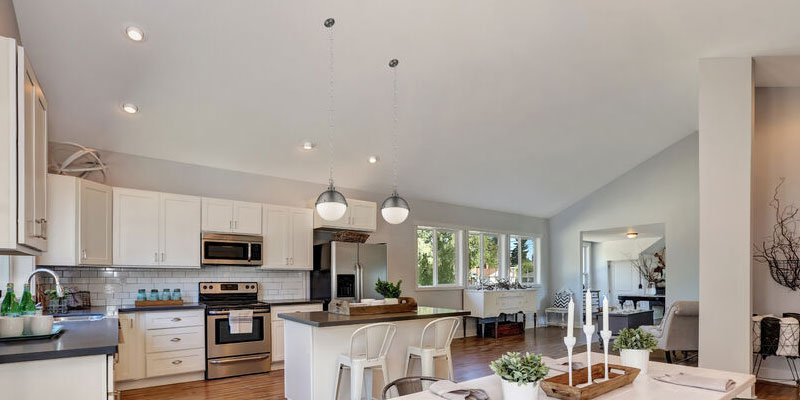 three hanging multi light pendants with a wood slat wall behind